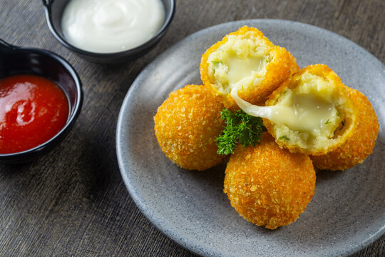 kroket kentang mozzarella, Fried potato croquettes with melted mozzarella cheese filling on a plate served with chili and mayo dip
