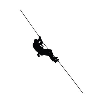 Silhouette of a climber traversing a steep rope line on a mountain