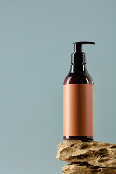 Luxury cosmetic pump bottle on a natural stone base. Minimalist mockup with earthy tones for premium skincare, body lotion, or hair care brands