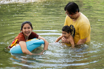 Obraz premium Happy Asian family playing together in river water