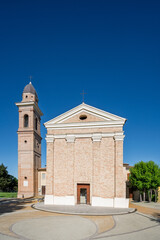 Fototapeta premium Front view of the Church of San Rocco in Trebbio near Montegridolfo in the Emilia Romagna region of Italy showing brick facade and bell tower under clear blue sky in morning light