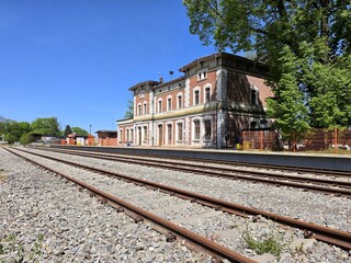 Fototapeta premium Historic brick railway station building with multiple tracks in Poland