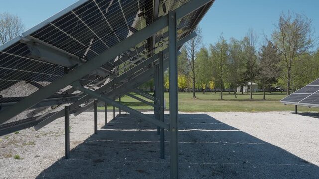 Engineering solution for bifacial photovoltaic solar panel installation. Metal racking system and wiring on white gravel ground for optimized albedo and renewable energy generation yield.