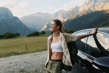 A woman beside a car in a mountainous landscape, wearing a white top and casual jacket, conveys...