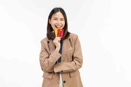 Happy young Asian businesswoman holding multiple credit cards with a confident smile isolated on white studio background.