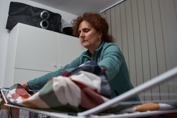 Obraz premium Woman hanging laundry on drying rack