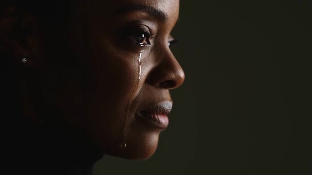 African female sheds tears displaying intense sorrow deep sorrow fills her eyes completely sorrow creates dramatic atmosphere sorrow resonates with audience emotions strongly.