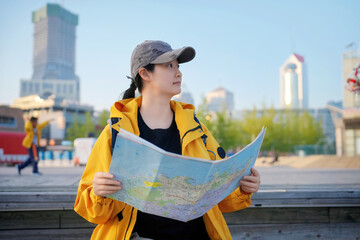Fototapeta premium A female traveler looking at a city map while sightseeing outdoors