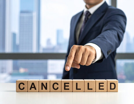 cancelled - Geschäftsmann zeigt auf den Text "cancelled"
