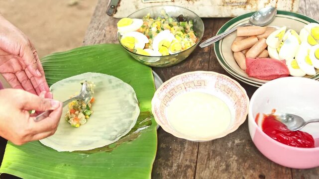 Person preparing traditional indonesian spring rolls