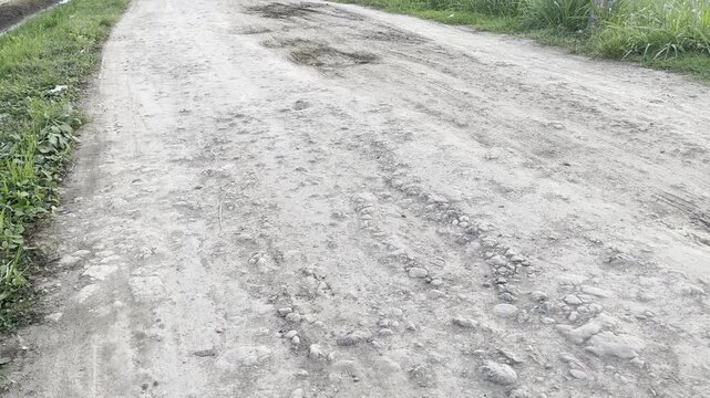 Damaged Dirt Road with Potholes in Rural Area