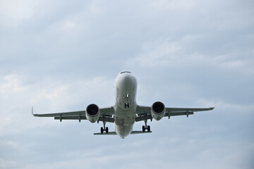 Fototapeta premium Commercial White Jet Plane Coming in for Landing, Front View – Air Travel Concept