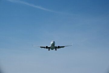Fototapeta premium Commercial White Jet Plane Coming in for Landing, Front View