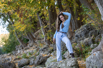 Naklejka premium Full body portrait of a young beautiful woman in blue jeans