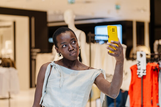 Trendy Black Woman Posing for Selfie with Smartphone in Fashion Mall