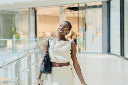 Radiant African American Woman Smiling with Shopping Bag in Retail Space