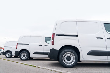 White delivery vans are parked in rows. Commercial fleet of vehicles © scharfsinn86