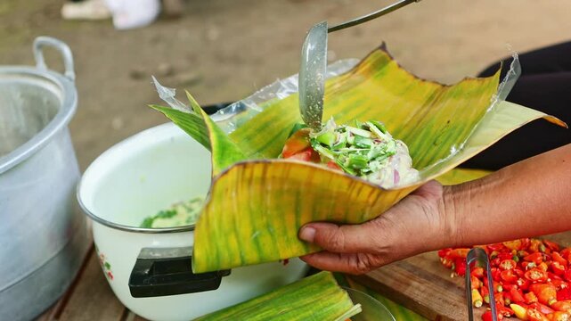 Indonesian woman preparing traditional garang asem chicken