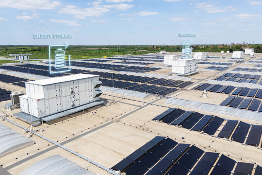 Aerial view of a modern factory with solar panels and energy storages on the roof