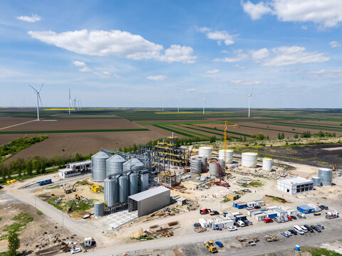 Construction of a modern agricultural grain terminal with wind turbines on the horizon