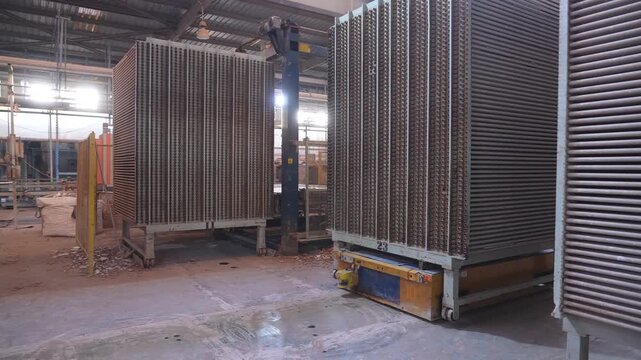 Industrial robot transporting ceramic tile racks in factory storage and production workflow
