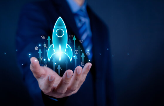 Businessman holding glowing rocket launch icon with upward arrows, symbolizing startup growth, innovation, success strategy, digital transformation, and business development in modern technology era