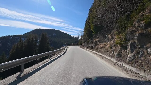 Car ride on a spring day in the Carpathian Mountains, a winding mountain road.