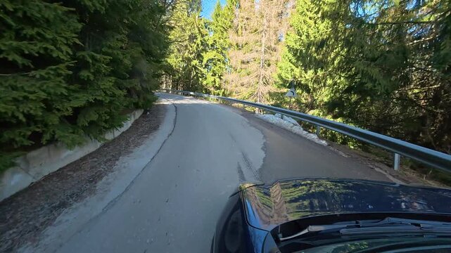 Car ride on a spring day in the Carpathian Mountains, a winding mountain road.