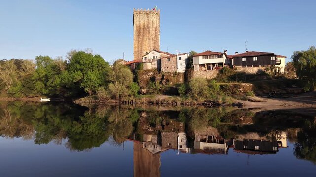 Lapela tower a medieval castle reflecting in the calm waters of minho river