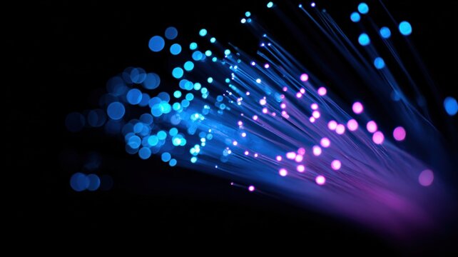 Close-up of glowing blue and purple fiber optic strands illuminating the darkness