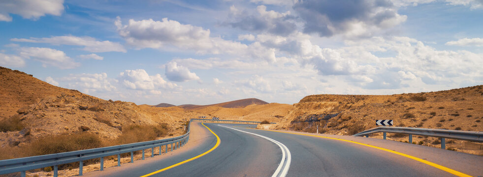 Driving a car on the mountain road in the desert. View of sandstone mountains through the windscreen. The road from Arad to the Dead Sea. Israel