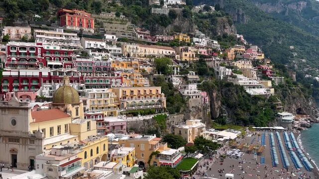 view of the colorful buildings of Positano, nestled against the green mountainside, creating a striking contrast, Positano, Amalfi Coast, Italy