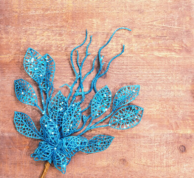 Christmas decorative blue glitter leaves on wooden background