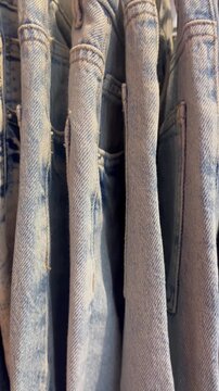 Close up of blue denim jeans hanging on a rack in a clothing store