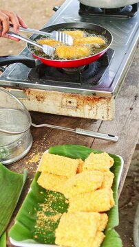 Person deep frying traditional indonesian risol mayo street food