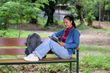 Fototapeta premium Young student learning outdoors using digital tablet
