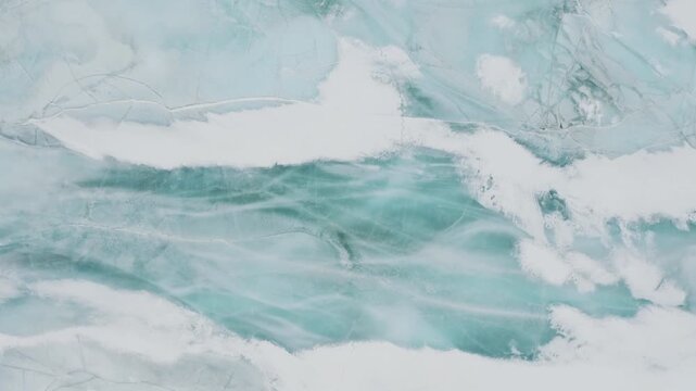 There is a beautiful color contrast between the clear crystal ice cubes and the white snow layers that form natural abstract patterns.