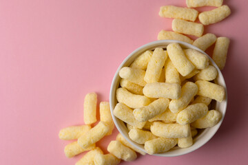 Obraz premium Crunchy Corn Puffs Closeup. Playfully Scattered Puffed Corn Pieces On Vibrant Surface For Advertisement