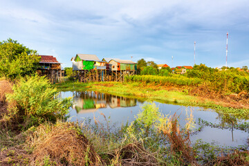 Fototapeta premium Cambodian stilt houses reflected in small pond
