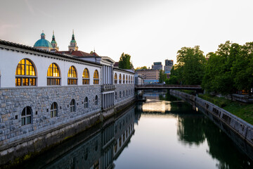 Riverside architecture and reflections along the Ljubljanica River in Ljubljana during sunset, featuring historic buildings, calm water and urban travel atmosphere in Slovenia. © JairoMZ