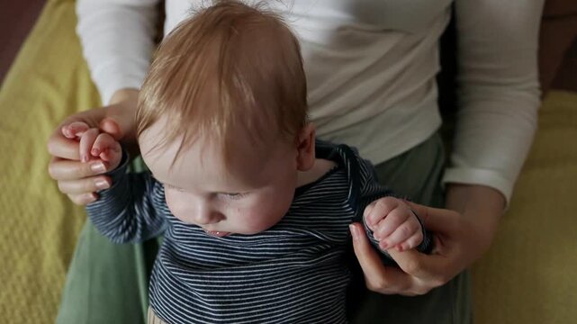 Sweet infant child bonding with parent at home, looking at camera with curiosity.