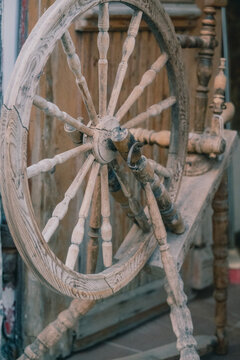 Antique Wooden Spinning Wheel Close-Up, Rustic Traditional Textile Craft Tool with Weathered Wood Grain and Historic Heritage Detail