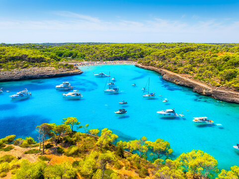 Aerial view of Cala Mondrago bay,  Balearic islands, Mallorca, Spain. Scenic coastline landscape with boats and yachts in summer. Mediterranean nature and vacation destination from drone.
