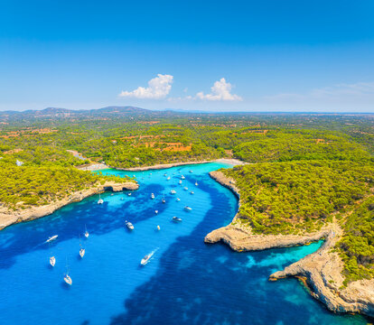 Aerial view of Cala Mondrago bay,  Balearic islands, Mallorca, Spain. Scenic coastline landscape with boats and yachts in summer. Mediterranean nature and vacation destination from drone.