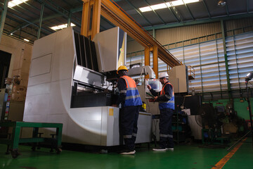Fototapeta premium Workers operate machines in a factory during the day in a manufacturing area