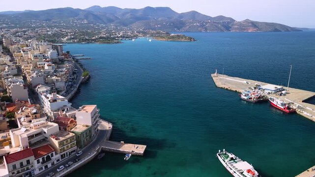 Greece Crete Agios Nikolaos 4K Drone Aerial Video Reveal at Sunset of Lake Voulismeni with Colorful Houses Scenic Harbor Channel and Mountains in Mist Travel