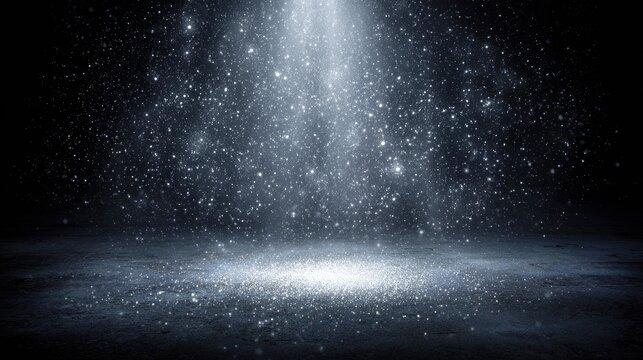 Bright beam of light illuminates falling glitter particles over a dark ground surface