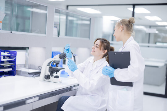 Scientists collaborate in a modern laboratory, sharing results and analyzing data on a tablet