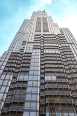 Obraz premium A close-up view of a modern skyscraper with many floors and windows. Urban architecture, building facade, city detail.
