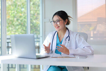 Female doctor working on laptop, providing remote healthcare services and virtual consultations in her office © amnaj